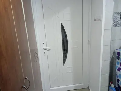 a white door with a round window in a bathroom at Apartman MARA in Bor