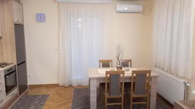 a kitchen and dining room with a table and chairs at Apartman SN in Vrnjačka Banja