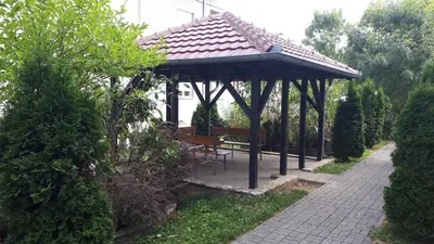 a bench under a gazebo in a garden at Apartman SN in Vrnjačka Banja