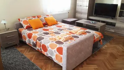 a bedroom with a large bed with orange pillows at Apartman SN in Vrnjačka Banja