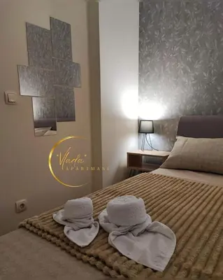 a bedroom with a bed with towels on it at Vlada apartmani in Vrnjačka Banja
