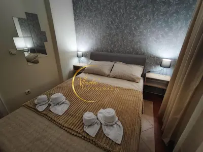 a small bedroom with a bed with towels on it at Vlada apartmani in Vrnjačka Banja
