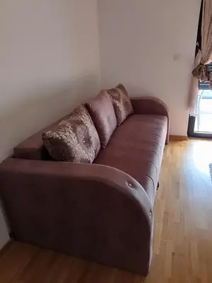 a brown couch with two pillows on it in a room at Studio Kalina in Vrnjačka Banja