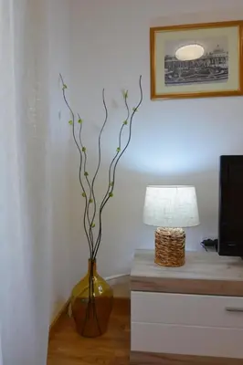 a vase with a plant in it next to a lamp at Studio apartman Sara in Vrnjačka Banja
