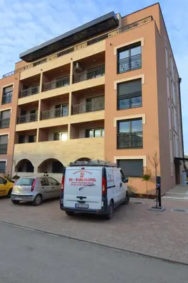 a white van parked in a parking lot in front of a building at Studio apartman Sara in Vrnjačka Banja