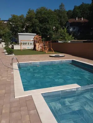 a swimming pool in a yard with a playground at Studio apartman Sara in Vrnjačka Banja