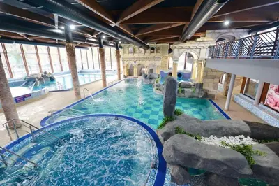 a large pool with a water slide in a building at Studio apartman Sara in Vrnjačka Banja