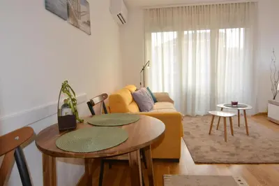 a living room with a couch and a table and chairs at Studio apartman Sara in Vrnjačka Banja