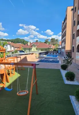 a playground with a swing in the middle of a yard at Studio apartman Sara in Vrnjačka Banja