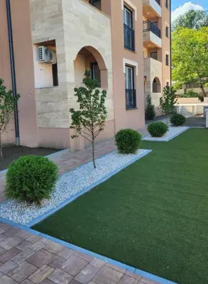a building with a tree in the middle of a yard at Studio apartman Sara in Vrnjačka Banja