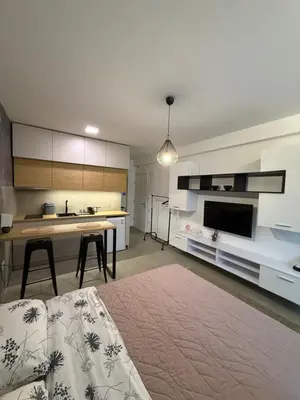 a living room with a table and a kitchen at Apartment Niš in Niš