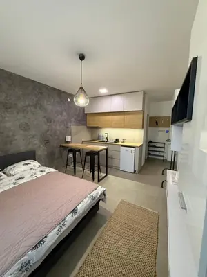 a bedroom with a bed and a table and a kitchen at Apartment Niš in Niš