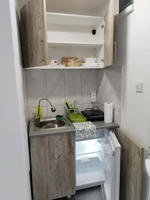 a small kitchen with a sink and an open refrigerator at Vikendica Aki in Zaječar