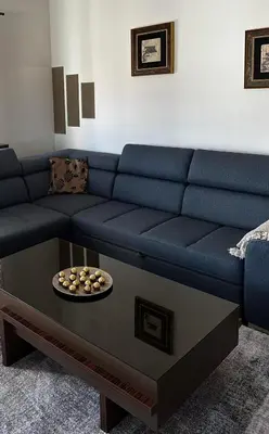 a blue couch with a coffee table in a living room at L&D apartman in Kruševac