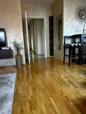 a living room with a wooden floor and a table at L&D apartman in Kruševac