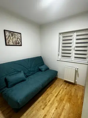 a green couch in a living room with a window at L&D apartman in Kruševac