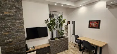 a living room with a table and a plant at Sen's Studio in Leskovac