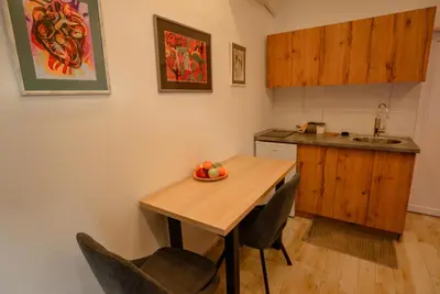 a small kitchen with a wooden table and chairs at Sen's Studio in Leskovac