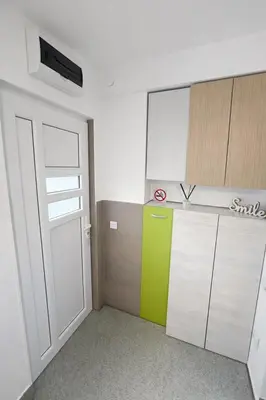 a room with a kitchen with a green door at Nilton 2 Apartmans in Niš