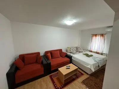 a living room with a couch and a bed at Apartmani Ušće in Trstenik