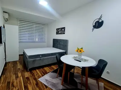 a bedroom with a bed and a table and chairs at Babuska studio in Jagodina
