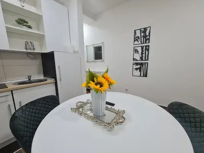 a vase of flowers sitting on a table in a kitchen at Babuska studio in Jagodina