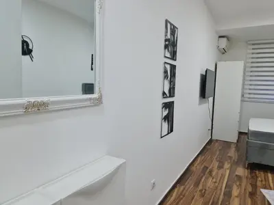 a white room with a mirror and a tv at Babuska studio in Jagodina