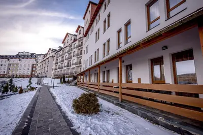 a row of buildings with snow on the ground at Alethea Lux Apartments, Milmari Resort Kopaonik in Kopaonik