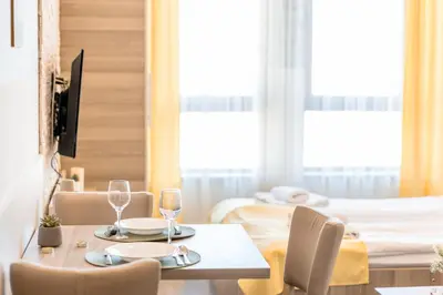 a dining room with a table and chairs and a bed at Alethea Lux Apartments, Milmari Resort Kopaonik in Kopaonik