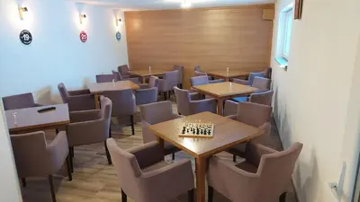 a dining room with tables and chairs and a chessboard at Apartments Tatic in Kopaonik