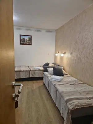 a bedroom with two beds in a room with a door at Apartments Tatic in Kopaonik