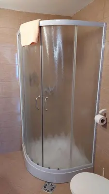 a shower stall in a bathroom with a towel at Apartments Tatic in Kopaonik