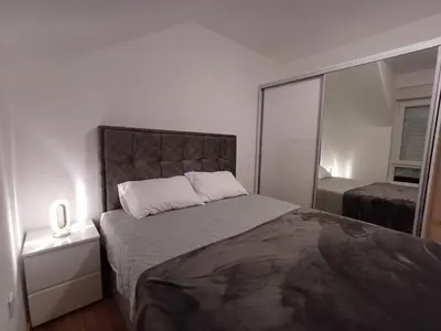 a bedroom with a large bed and a mirror at Dva brata in Soko Banja