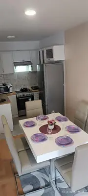a kitchen with a table with purple plates on it at Apartman LARA in Pirot