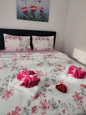 a bed with two towels and a pair of shoes on it at Apartman LARA in Pirot