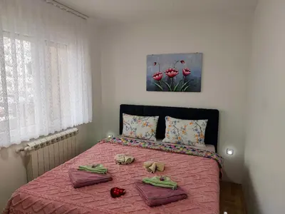 a bedroom with a pink bed with two towels on it at Apartman LARA in Pirot