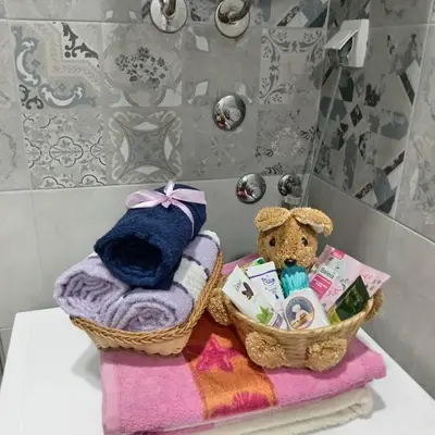 a bathroom with two baskets of towels and a teddy bear at Apartman LARA in Pirot