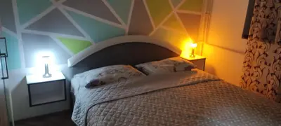 a bedroom with a bed with two lamps on two tables at Jednosoban stan centar Ela, in Pirot