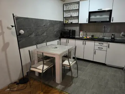 a kitchen with a table and chairs in a kitchen at Jednosoban stan centar Ela, in Pirot