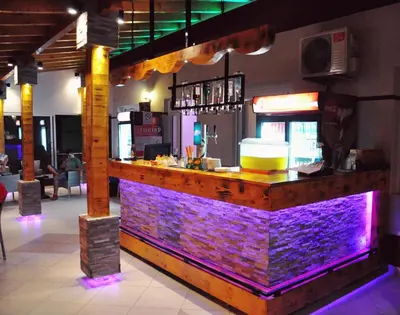 a bar with purple lighting in a restaurant at Rooms Turist in Vladičin Han