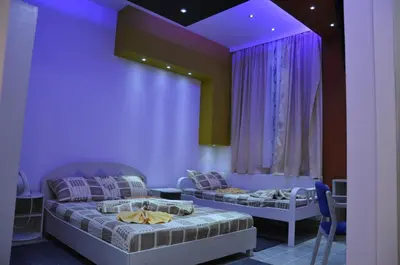 two beds in a room with purple walls at Rooms Turist in Vladičin Han