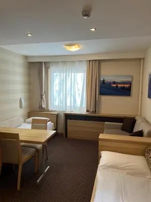a hotel room with two beds and a table at Apartments Suncani Vrhovi Kopaonik in Kopaonik