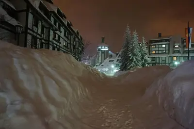 a pile of snow on a city street at night at Apartments Suncani Vrhovi Kopaonik in Kopaonik