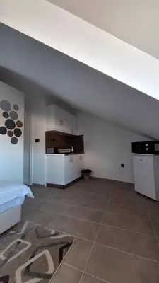 an attic room with a bed and a kitchen at Kopaonik - Milmari resort S65 in Kopaonik