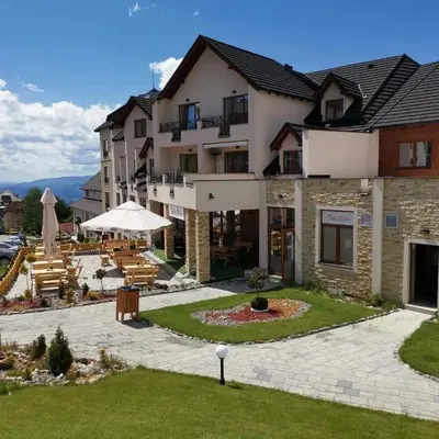 a large building with a patio and tables and chairs at Kopaonik - Milmari resort S65 in Kopaonik