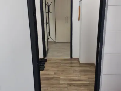 a hallway with a mirror and a wooden floor at Junona Magenta in Prokuplje