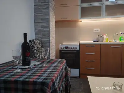 a bottle of wine sitting on a table in a kitchen at Junona Magenta in Prokuplje