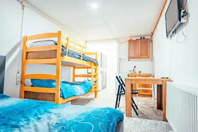 a room with bunk beds and a desk and a table at STD Stara Vodenica in Crni Vrh