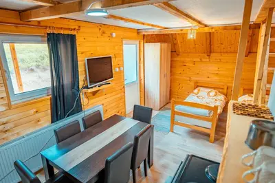 a dining room with a table and chairs and a television at STD Stara Vodenica in Crni Vrh