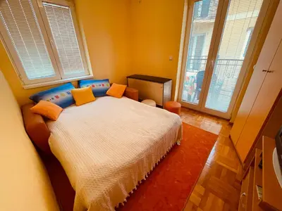 a bedroom with a bed with orange and blue pillows at Just like home in Vrnjačka Banja